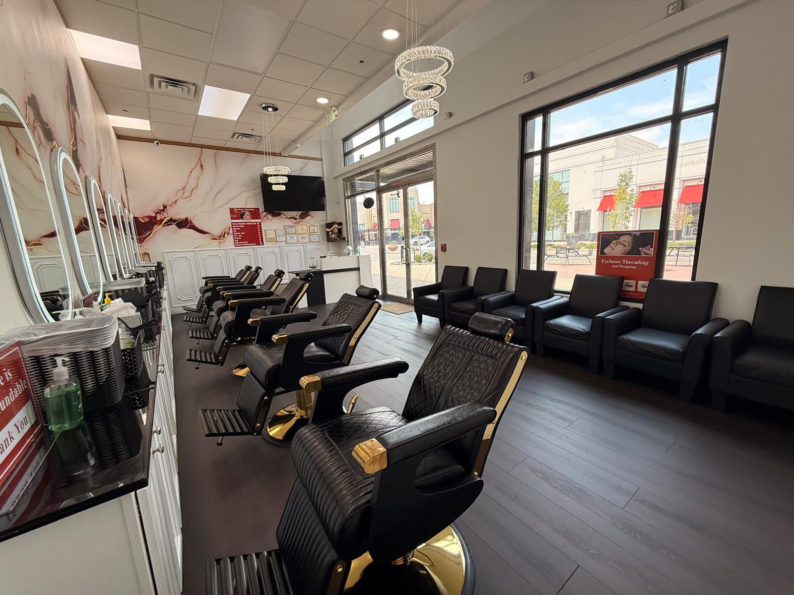 LED-lit oval mirrors against marble wall inside Eyebrow Threading & Beauty
